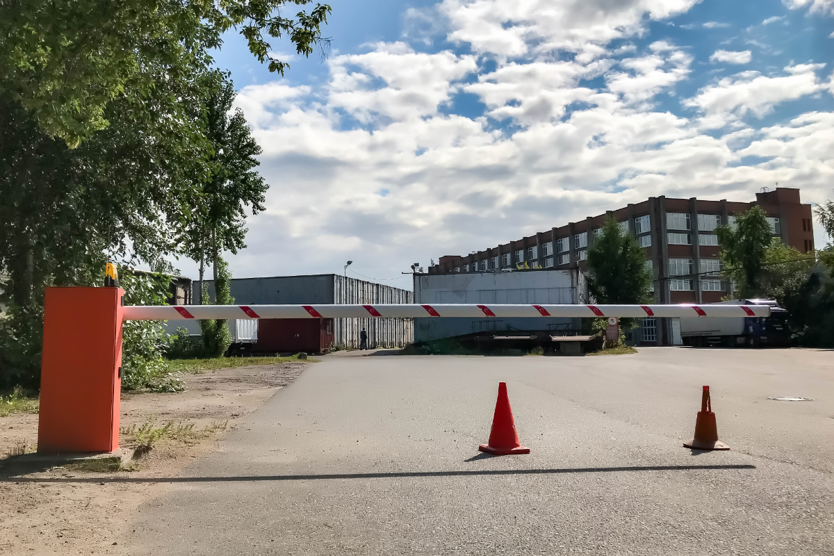 Barrier close-up on background of an industrial zone. Closed automatic barrier gate system for security. Automatic entry system to territory